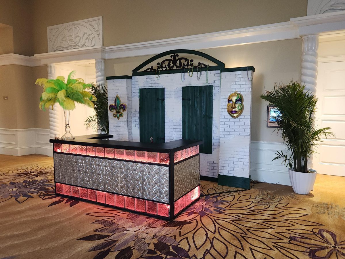 Aged brick back bar facade with green shutters and glass block bar