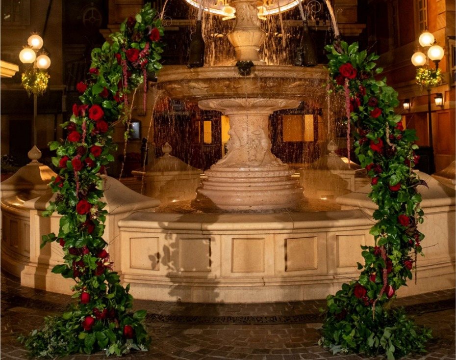Asymmetrical arch with red roses and greenery
