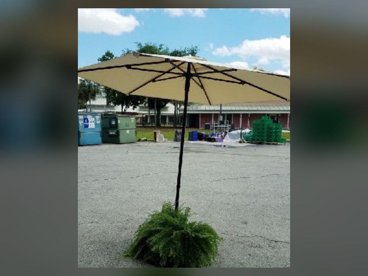Beige market umbrella with weighted base
