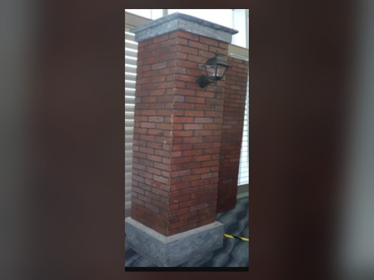 Freestanding red brick column with light sconce