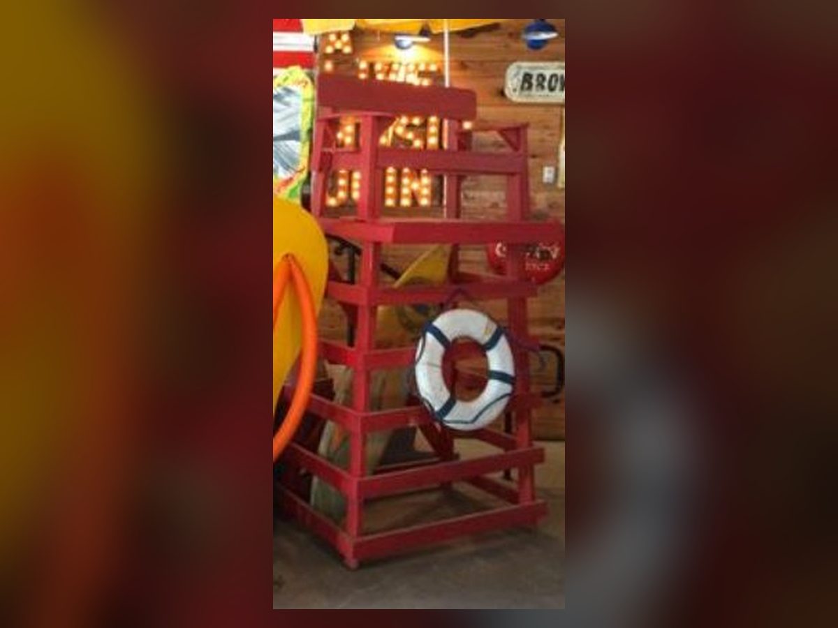 Red wooden lifeguard stand with life ring